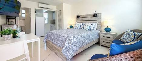 Une chambre à coucher avec un lit, des tables de chevet, un bureau et une chaise.