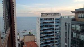A high-rise building with multiple balconies overlooking a beach. - Cozy Apt Sea View Barra - Nau0810 (Salvador)
