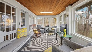 A sunroom with a wooden ceiling, large windows, and a zebra-patterned rug. - A-Frame w/ VIEWS | Walk to Downtown/Park | Pets OK (Mentone)