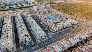 Vue aérienne d’un complexe résidentiel comprenant plusieurs immeubles d’appartements, une piscine et un réseau routier.
