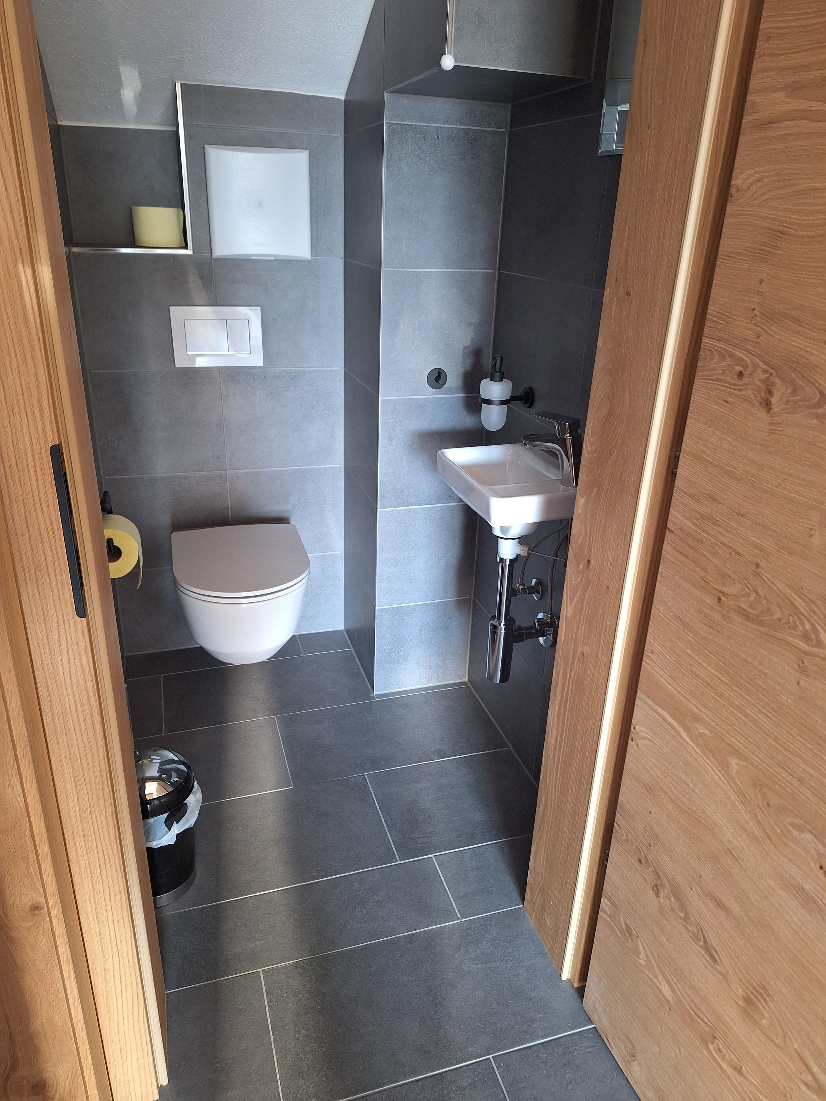 A modern bathroom with a toilet, sink, and shower.
