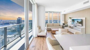 Un salon moderne avec vue sur la ville, un téléviseur à écran plat et un design minimaliste.