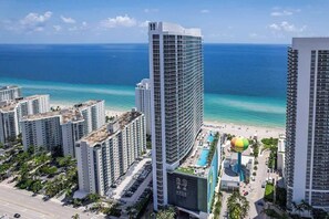 Ein Hochhaus-Hotel mit Poolbereich und Blick auf den Strand.