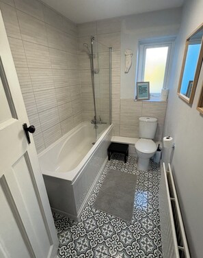 A bathroom with a bathtub, toilet, and shower. - Stunning Margate seaside retreat (Margate)