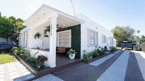 Una casa moderna con porche cubierto, garaje y entrada de grava y concreto.