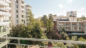 A multi-story residential building with balconies, surrounded by trees and other buildings. - Bright 2-bedroom apartment with heating system in beautiful Espoo (Espoo)