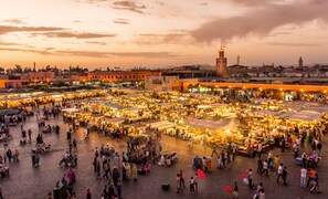 A bustling outdoor market with numerous stalls and people. - Palais Talilit (Marrakech)