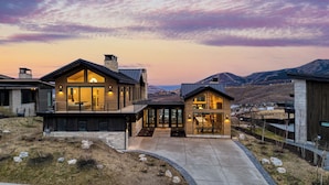 A modern two-story house with large windows, a stone chimney, and a view of the surrounding landscape. - 2 Min to Jordanelle Gondola Hot Tub Spa Suite Movie Room & Mountain Views Skyridge Summit by Avantstay (Heber City)