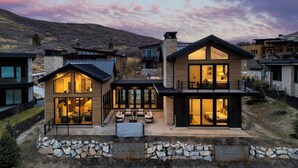 A modern two-story house with large windows, a stone facade, and a well-maintained outdoor patio area. - 2 Min to Jordanelle Gondola Hot Tub Spa Suite Movie Room & Mountain Views Skyridge Summit by Avantstay (Heber City)