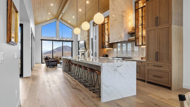 A spacious kitchen with a large island, wooden cabinets, and a view of a mountain. - 2 Min to Jordanelle Gondola Hot Tub Spa Suite Movie Room & Mountain Views Skyridge Summit by Avantstay (Heber City)