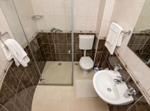 Ein kleines Badezimmer mit Dusche, Toilette und Waschbecken.