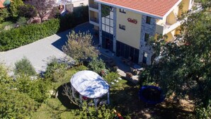 A multi-story building with a red-tiled roof, a visible sign reading "Glory," and a covered outdoor seating area. - Glory Sanctuary Retreat - Twin room with balcony 2 (Medugorje)