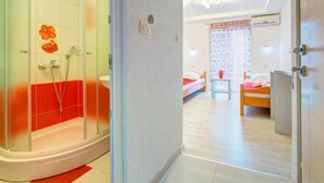A hotel room with a shower, a bed, a bedside table, and a wardrobe. - Glory Sanctuary Retreat - Twin room with balcony 2 (Medugorje)