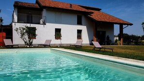 A house with a swimming pool, a balcony, and two lounge chairs. - CREMONA BUSSETO MUSIC - Villa with park and Pool. (San Giuliano)