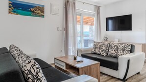 A modern living room with a sofa, a coffee table, and a TV. - Gorgeous home in Posedarje (Posedarje)