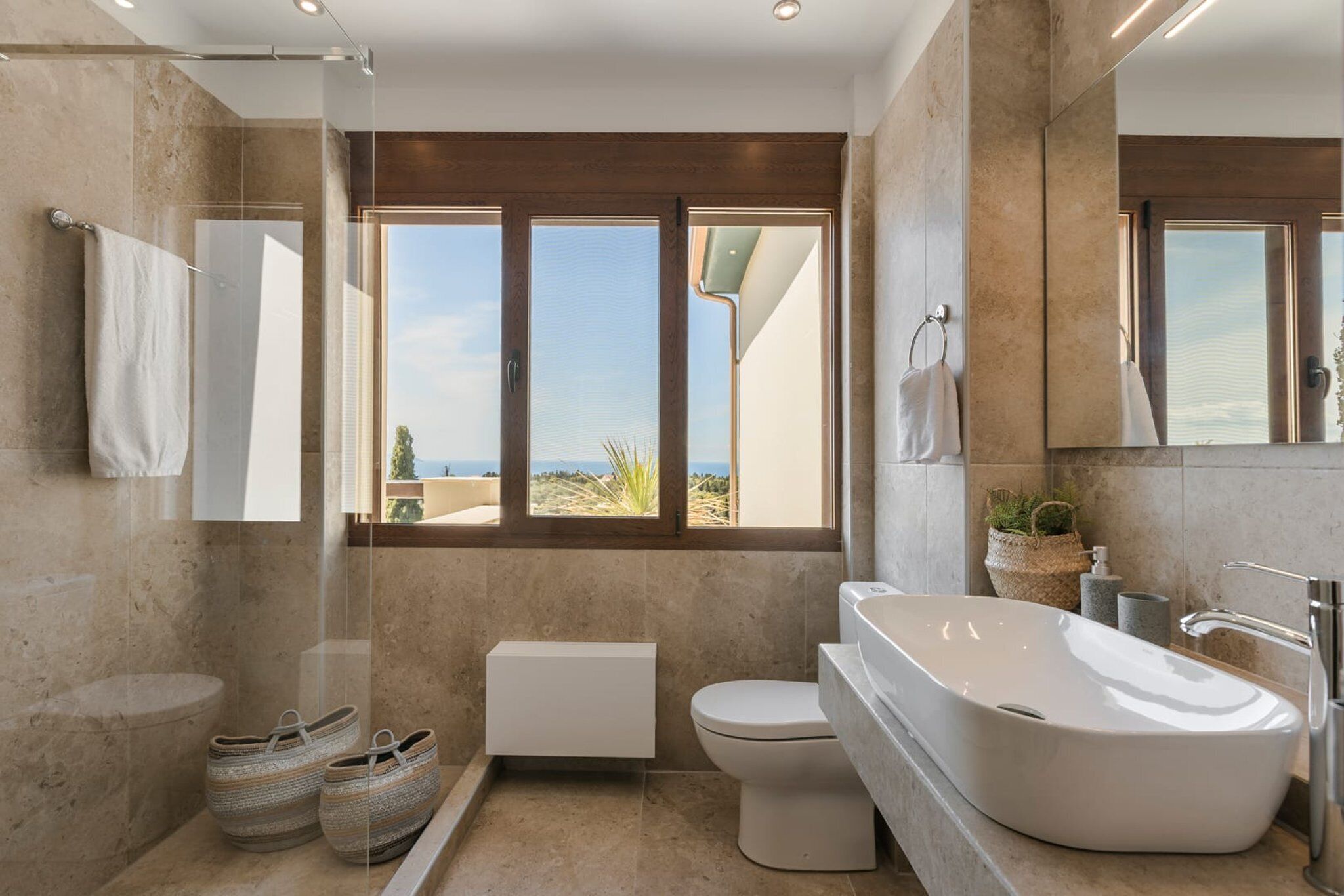 Un baño moderno con una bañera independiente, un inodoro y una cabina de ducha.