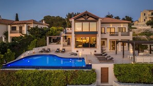 A modern two-story house with a swimming pool, large windows, and a patio area. - Villa Phoebeia, Wonderful Sea Views, Outdoor Infinity Pool, Antipata, Kefalonia (Kefalonia)
