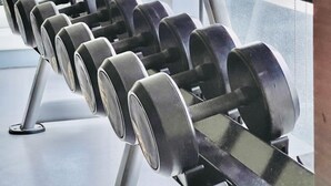 A row of dumbbells on a rack in a gym with large windows. - Stylish & Cozy Studio Retreat in Iloilo City (Iloilo City)