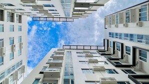 A modern high-rise building with multiple balconies and large windows, offering views of the sky. - Stylish & Cozy Studio Retreat in Iloilo City (Iloilo City)