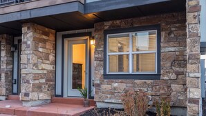 A stone facade with a door and windows, a small step leading to the entrance, and a potted plant on the step. - Rooftop Deck w/ Hot Tub Near Dining & Ski Slopes The Lookout by Avantstay (Park City)