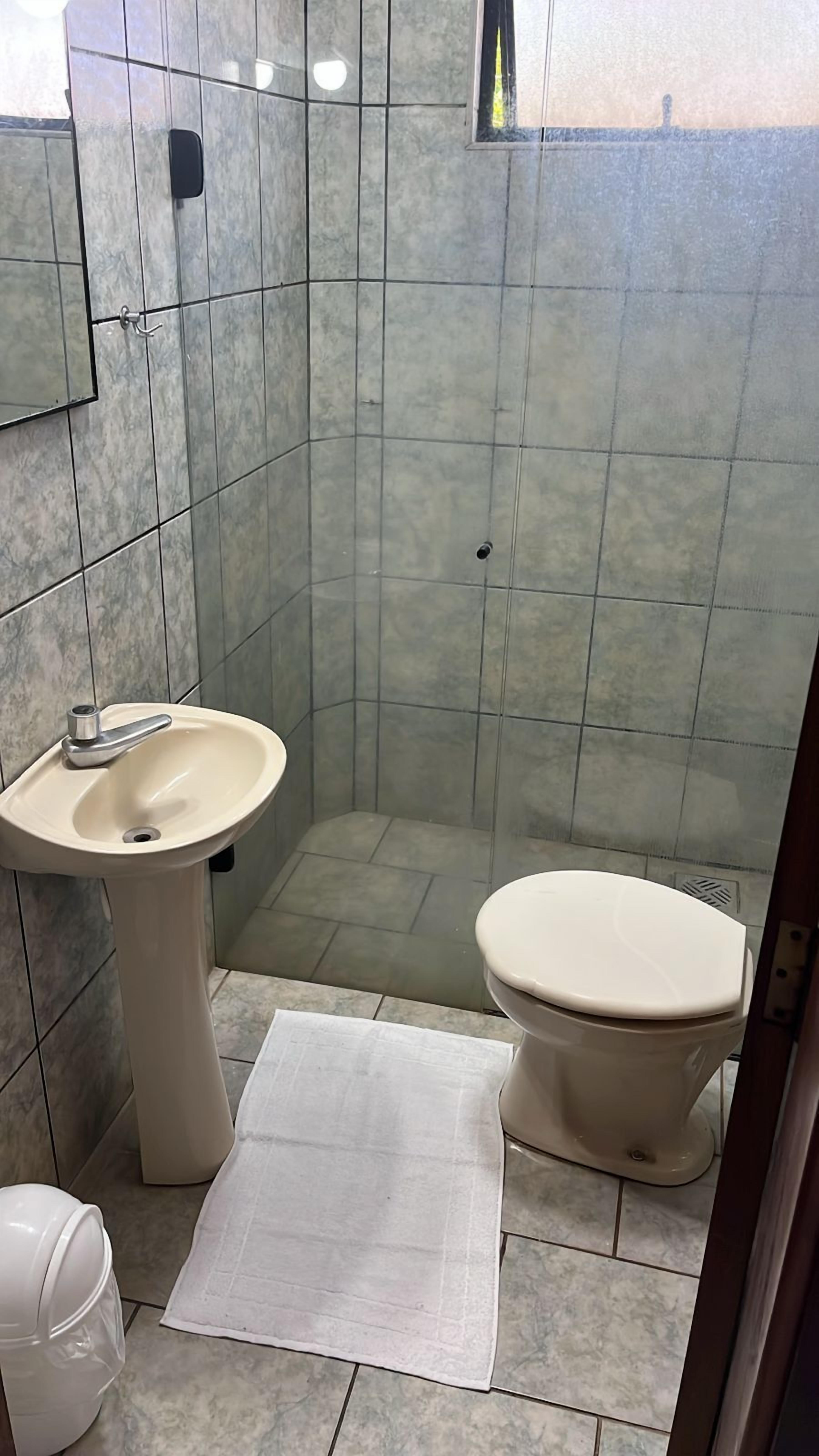 Un baño pequeño con lavamanos, inodoro y una pequeña ventana.