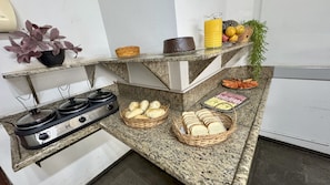 A kitchen counter with bread, a fruit basket, and a juice pitcher. - Périco Hotel (Igaracu Do Tiete)