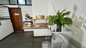 Eine kleine Küche mit eingebautem Herd, Spüle und Arbeitsplatte, auf der sich verschiedene Lebensmittel und ein Blumentopf befinden.
