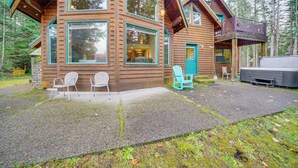 A wooden cabin with large windows, a deck, and outdoor seating. - 19 Mi to Slopes at Crystal Mtn: Getaway w/ Hot Tub (Enumclaw)