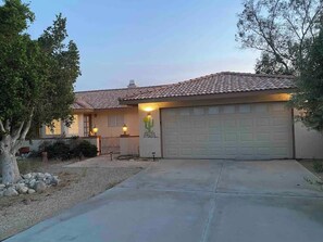 A residential house with a tiled roof, a garage, and a well-maintained driveway.