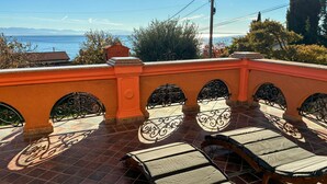A terrace with a view of the sea, featuring a tiled floor and a row of sun loungers. - Gorgeous apartment in Opric with house sea view (Opric)