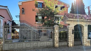 A gated entrance with a stone archway and a metal gate. - Gorgeous apartment in Opric with house sea view (Opric)