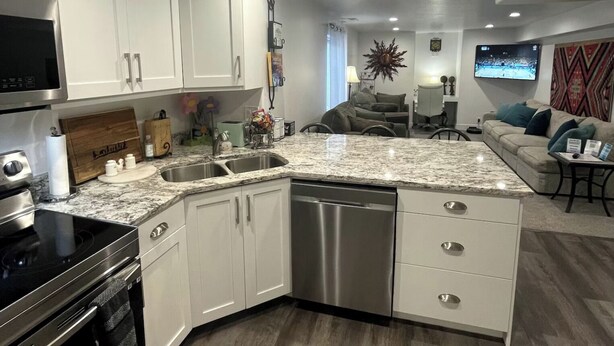 A modern kitchen with white cabinets, a granite countertop, stainless steel appliances, and a built-in dishwasher. - Guest Favorite, 5 Star Cozy 1-bedroom corporate apartment in perfect West Jordan (West Jordan)