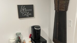 A small kitchenette with a coffee maker, a jar labeled 'COFFEE', and a sign that reads 'Life Begins After Coffee'. - Guest Favorite, 5 Star Cozy 1-bedroom corporate apartment in perfect West Jordan (West Jordan)