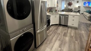 A modern kitchen with stainless steel appliances, white cabinetry, and a wooden floor. - Guest Favorite, 5 Star Cozy 1-bedroom corporate apartment in perfect West Jordan (West Jordan)