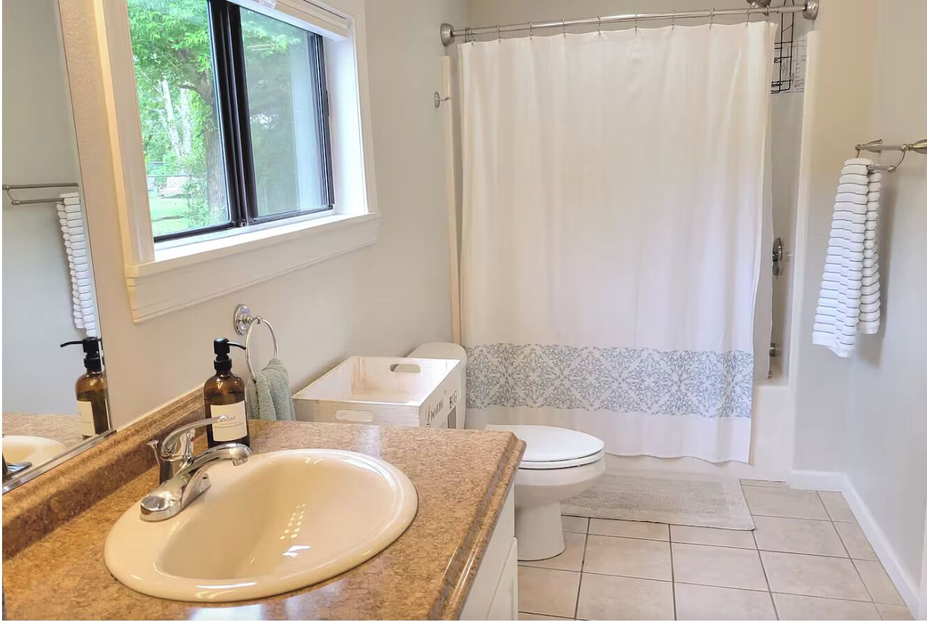 Ein Badezimmer mit Waschbecken, Toilette und Duschvorhang.