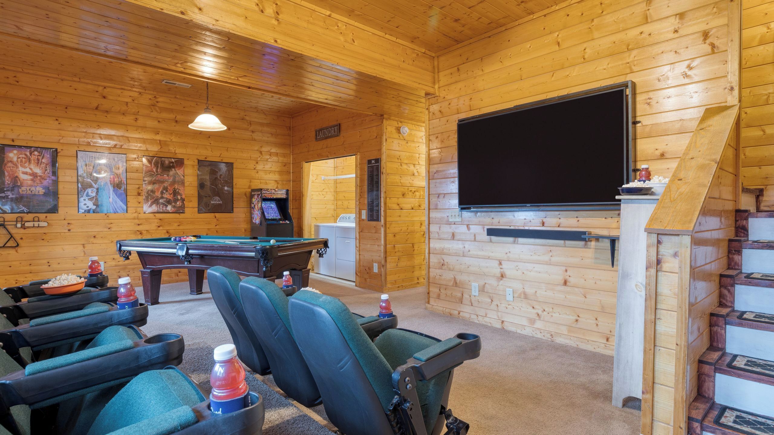 Ein gemütliches Zimmer mit Billardtisch, bequemen Sitzgelegenheiten, einem Fernseher und einer Waschgelegenheit.