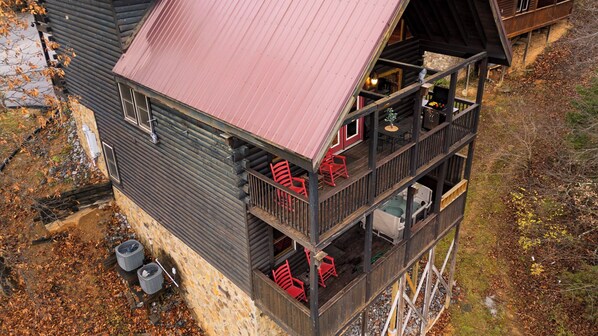 A multi-level cabin with a balcony, outdoor seating, and a grill area. - Game Room, Arcade, Theater, Hot Tub Near Pigeon Forge Skycrest by Avantstay (Sevierville)