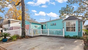 A turquoise house with a white fence, a garage, and a small porch. - BeachTimes and TanLines|GolfCart|Linens|OceanLakes (Horry County)