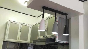 A kitchen with white cabinets, black marble backsplash, and a black countertop.