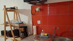 Una cucina compatta con forno a microonde, lavello e piccolo frigorifero.
