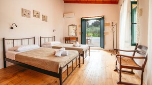 A room with two beds, a wooden ceiling, a desk, and a chair. - Traditional Anna's Stone House with Private Pool (Margarites)