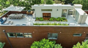 Eine moderne Dachterrasse mit Essbereich, einem kleinen Garten und einem Pool.