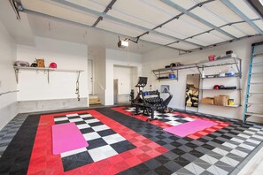 Ein Fitnessraum mit Gummimatten, Gewichtstrainern und Regalen mit Artikeln.