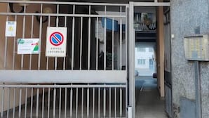 A gated entrance to a building with a no parking sign, a staircase leading inside, and a view of the interior through the gate. - Short Rent Milan Porta Romana  (Milan)