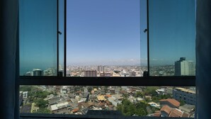 Un rascacielos con vista a un paisaje urbano a través de un ventanal grande.