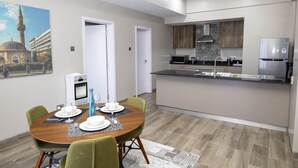 Un appartamento moderno con zona pranzo, cucina e vista su una moschea.