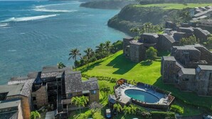 A coastal resort with stone buildings, a swimming pool, and ocean views. - Oceanfront Eagle’s Nest - Bali Hai Sunset Views (Princeville)