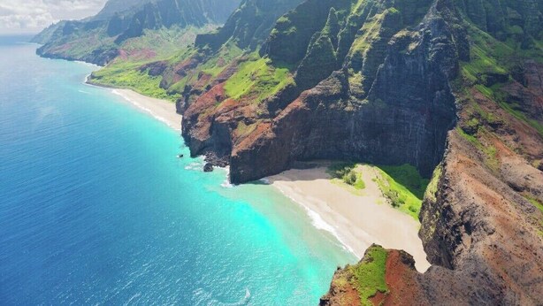 A coastal landscape with a beach, cliffs, and clear blue waters. - Oceanfront Eagle’s Nest - Bali Hai Sunset Views (Princeville)