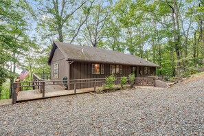 A rustic cabin with a wooden deck, a small porch, and a gravel driveway. - Mountain Magic in the Wolf Laurel Community (Mars Hill)