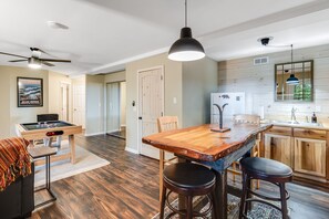 A modern kitchen with wooden cabinets, a central island, bar stools, and a ceiling fan. - Mountain Magic in the Wolf Laurel Community (Mars Hill)